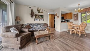 Un salon spacieux comprenant un canapé, une table basse et un coin repas avec des chaises.