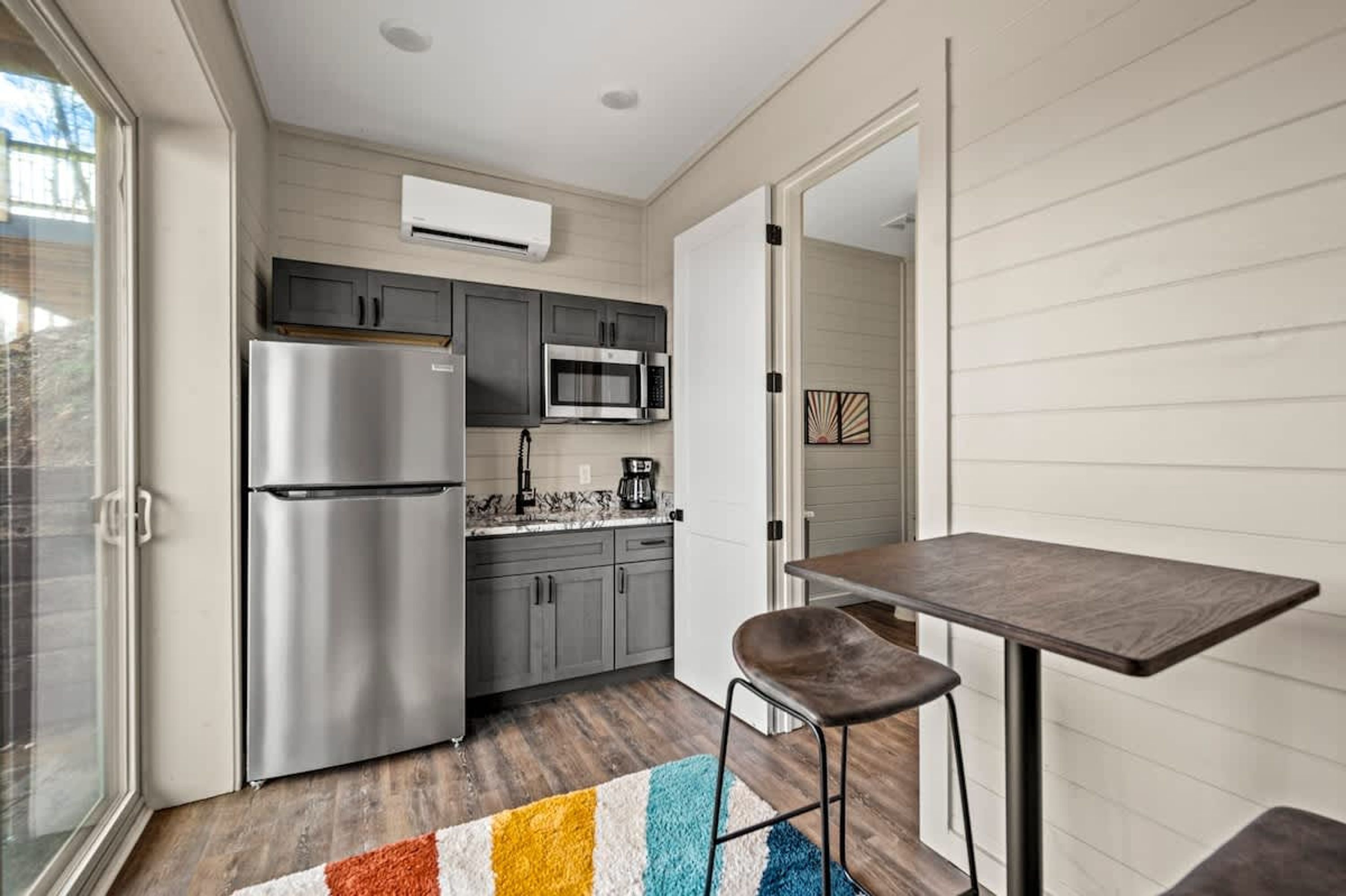 A compact kitchen with a refrigerator, microwave, and sink.