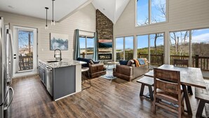A spacious living area with a kitchen, dining table, and seating. - NEW Lake View Indoor Pool Sleeps 14 Hot Tub (Sevierville)