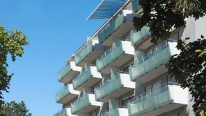 A multi-story building with balconies, a satellite dish, and a clear blue sky. - Two-room PREMIUM apartment (Ostfildern)