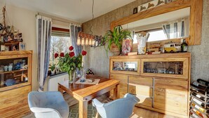 A cozy room with a wooden dining table, two chairs, a ship model, and a wine rack. - Two-room PREMIUM apartment (Ostfildern)