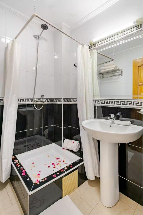Ein Badezimmer mit Badewanne, Waschbecken und Dusche.