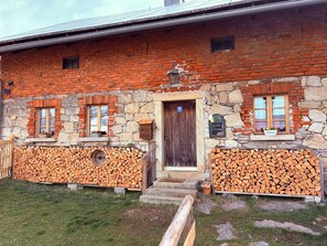 A rustic building with a stone facade, wooden door, and windows with flower boxes.