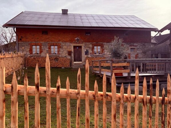 A rustic stone building with a wooden fence in the foreground.