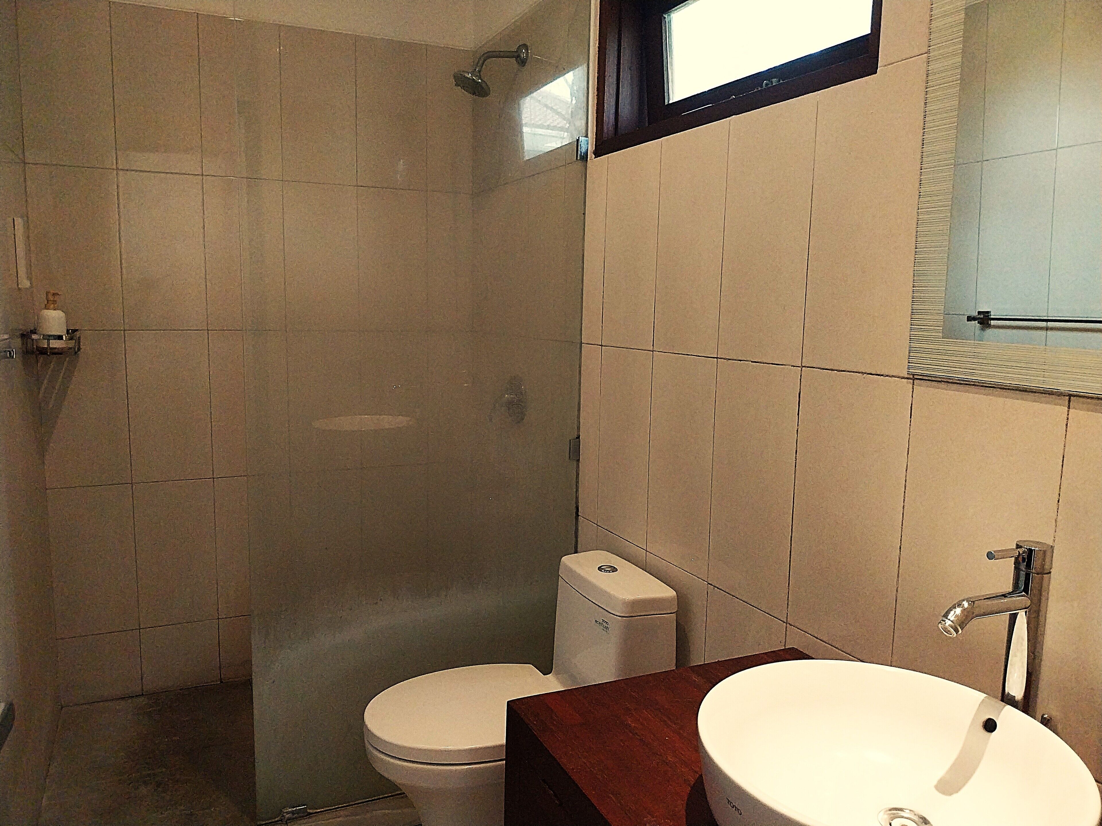 A bathroom with a shower, toilet, and sink.