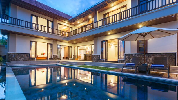 A two-story building with a swimming pool, outdoor seating, and a balcony. - Villa Sabasanti (Blahbatuh)