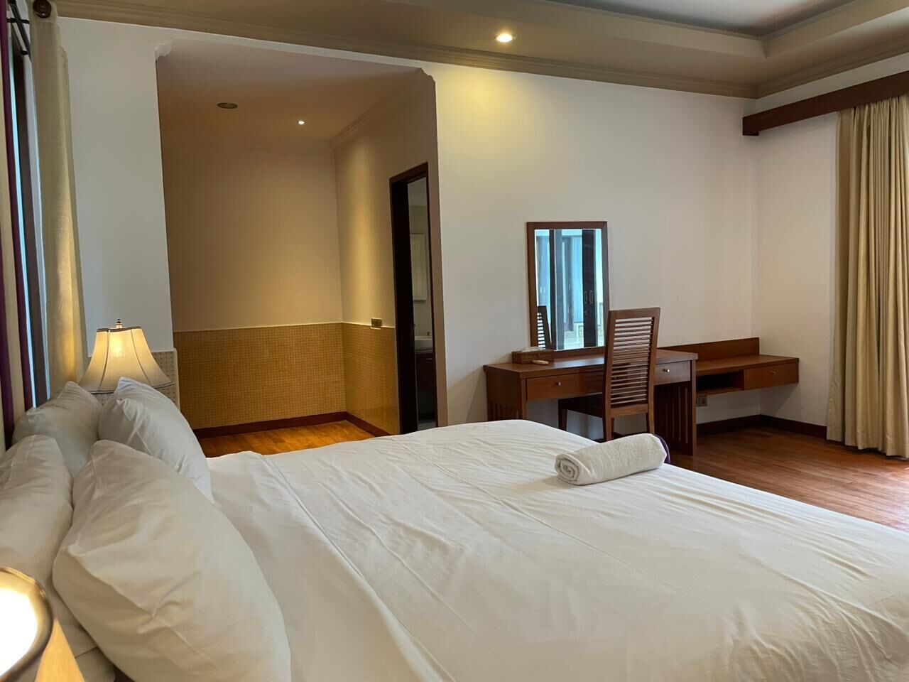 Una habitación de hotel con una cama grande, un escritorio y una silla.