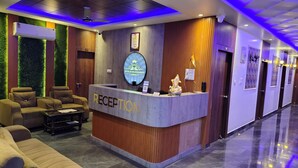 A hotel reception area with a modern design, featuring a reception desk, seating area, and a wall-mounted air conditioning unit. - HOTEL RUDRA RESIDENCY (Patna)