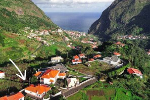 A coastal village with houses, a road, and a view of the sea. - Casa Brisa - by PrimeStayMadeira (São Vicente)