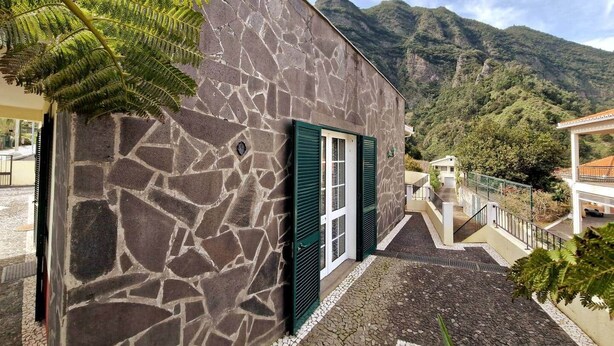 A stone building with a staircase leading to a balcony, surrounded by mountains. - Casa Brisa - by PrimeStayMadeira (São Vicente)