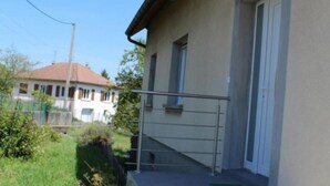 A building with a beige exterior, a metal staircase, and a small window.