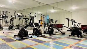 A gym with various exercise machines and a colorful floor pattern. - GuestHouse Lugano University (Lugano)