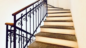 A staircase with a black metal railing and stone steps. - GuestHouse Lugano University (Lugano)