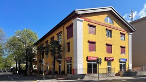 A yellow building with a sign for a guest house and a restaurant. - GuestHouse Lugano University (Lugano)
