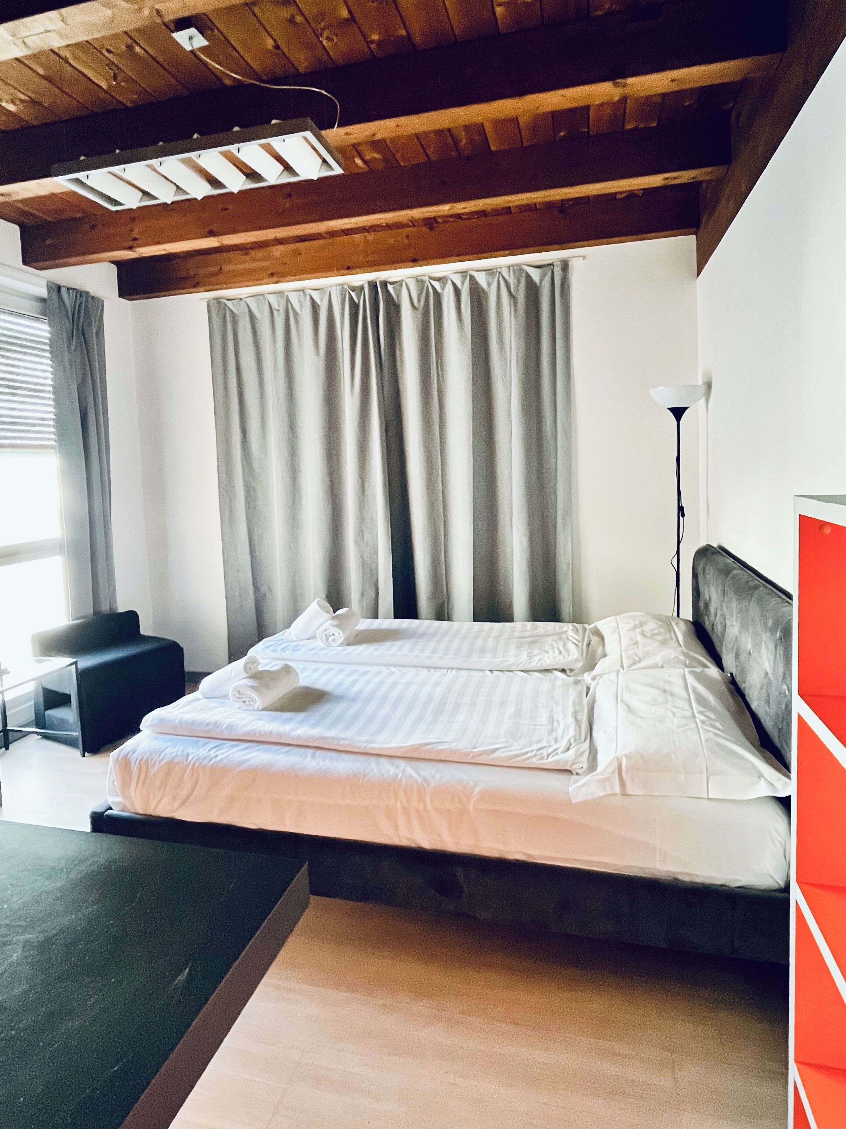 Une chambre à coucher avec un lit, un bureau, une chaise et une lampe.