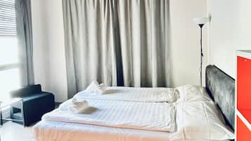 Une chambre à coucher avec un lit, un bureau, une chaise et une lampe.