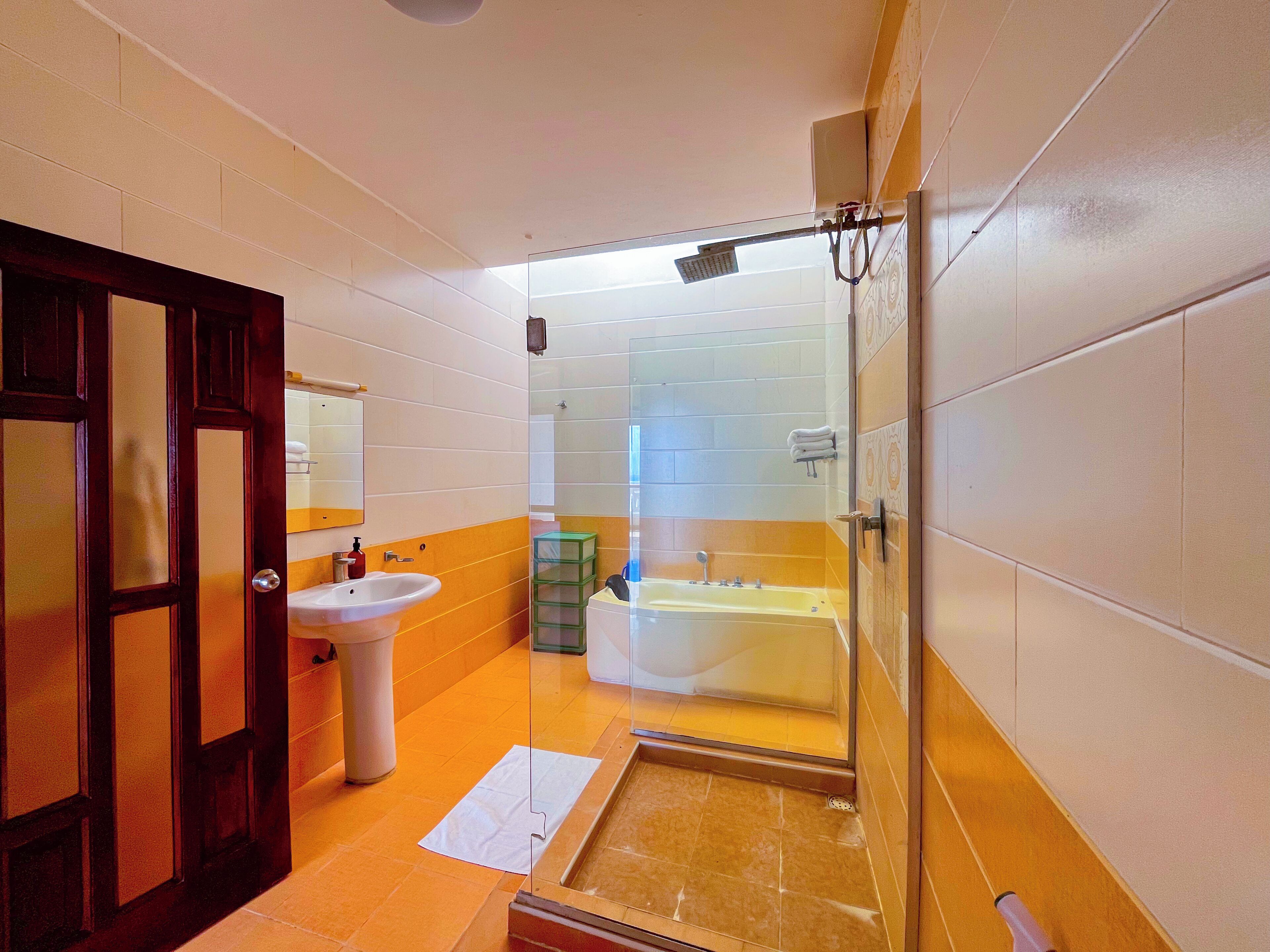 A bathroom with a glass shower enclosure, a sink, and a bathtub.