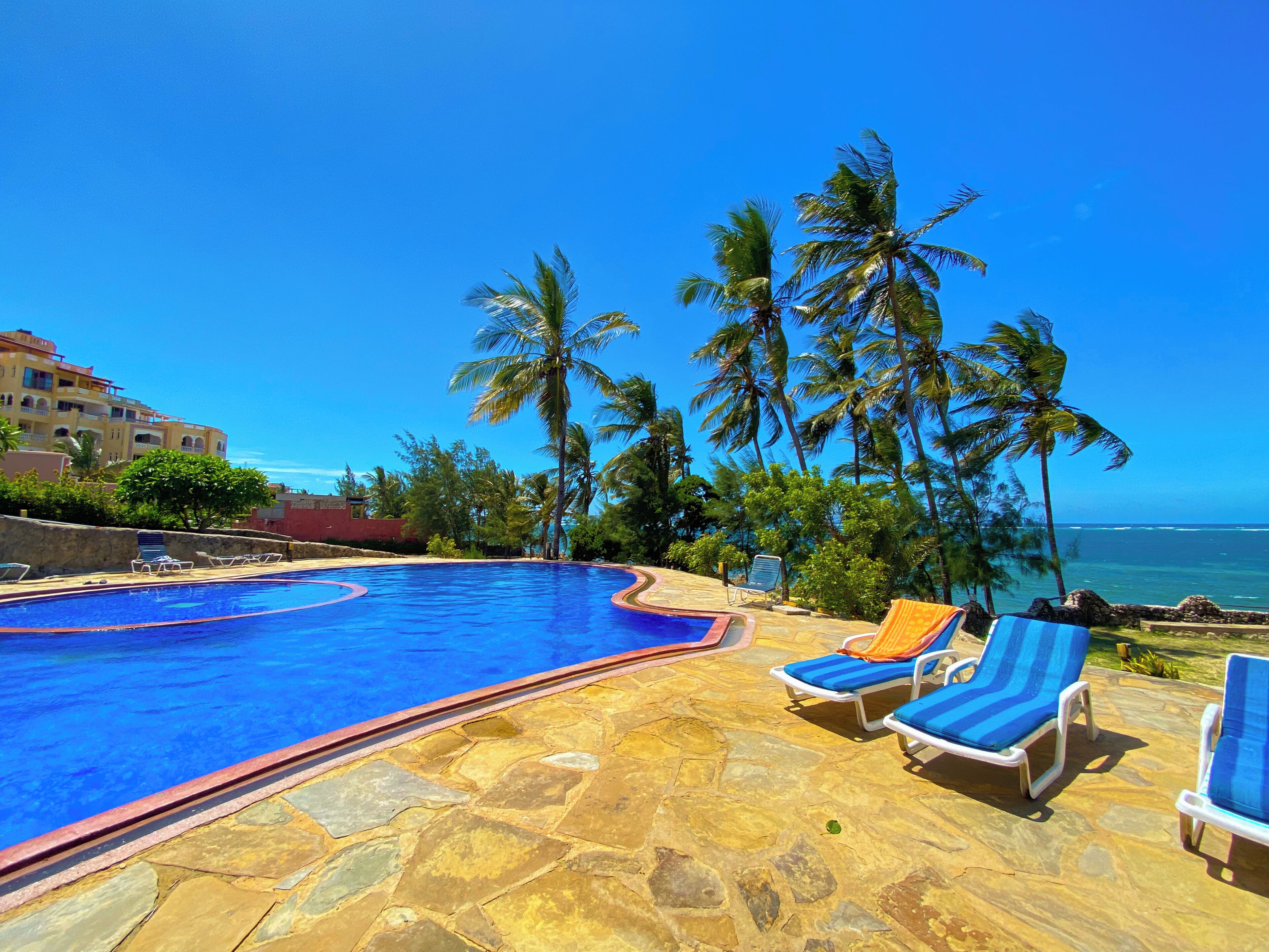 Una piscina al aire libre, sillones reclinables de piscina