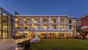 A modern building with multiple floors, large windows, and a well-lit entrance area. - MACAM Hotel (Lisbon)