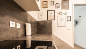 Un interno moderno dal design minimalista, con una parete in cemento, un pavimento riflettente e opere d'arte incorniciate alle pareti.