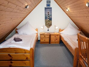 A cozy attic bedroom with two wooden beds, a small desk, and a decorative wall hanging. - Stunning  villa for 4 people with WIFI, TV and terrace (Norden)