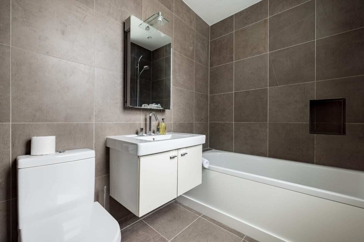 A modern bathroom with a toilet, sink, and bathtub.