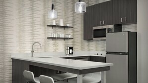 Una cocina moderna con una isla central, electrodomésticos de acero inoxidable y un diseño minimalista.