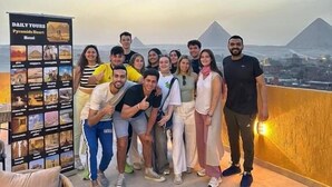 A group of people posing on a balcony with a view of pyramids. - Pyramids Heart Hotel (Giza)