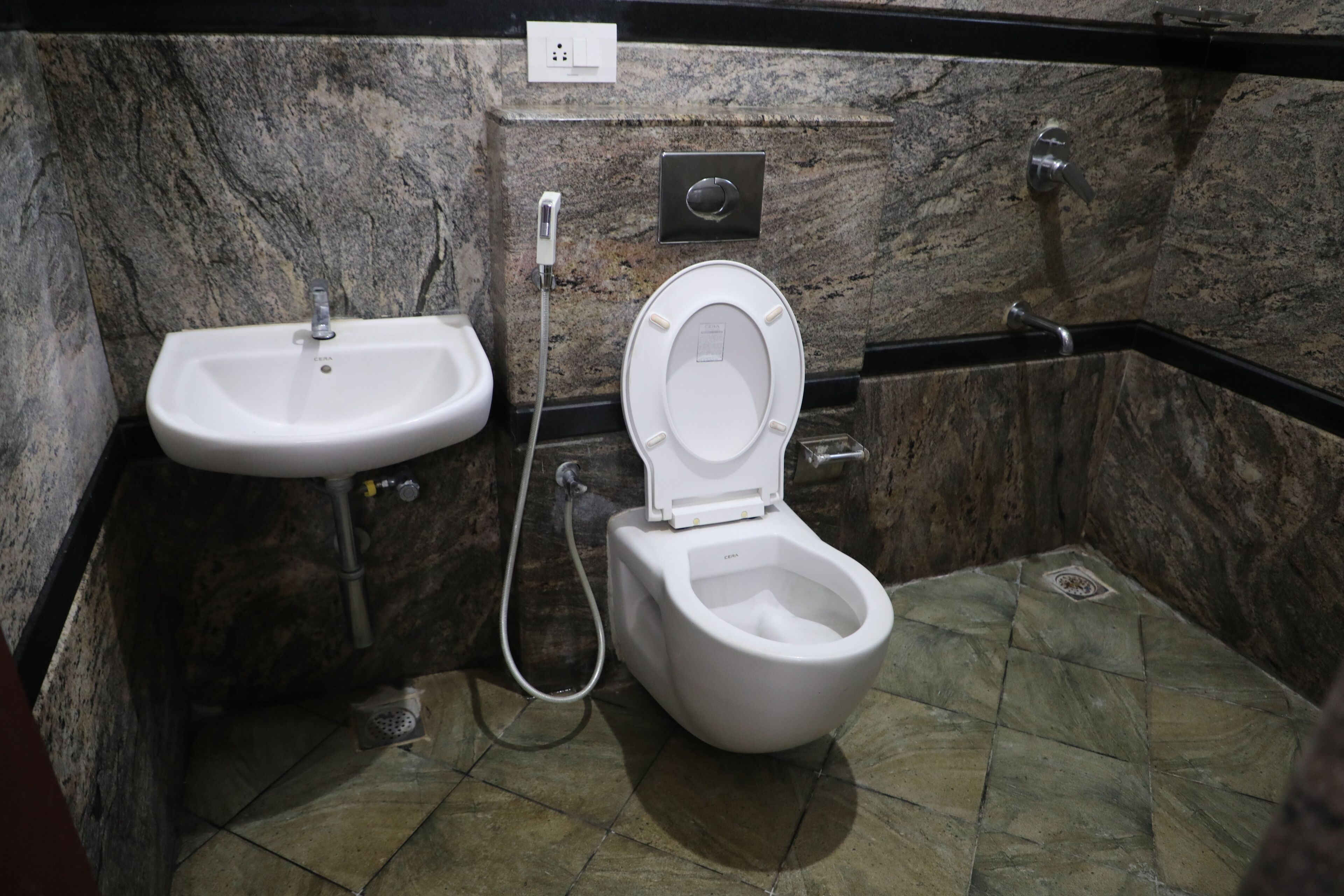 Ein Badezimmer mit einem weißen Waschbecken, einer Toilette und einer Dusche.