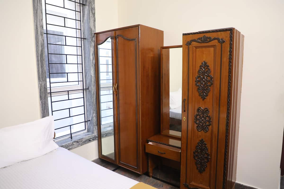 A bedroom with a bed, a wardrobe, and a mirror.