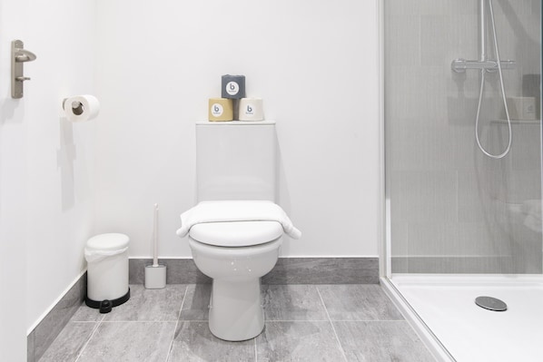 A modern bathroom with a toilet, bidet, and shower.