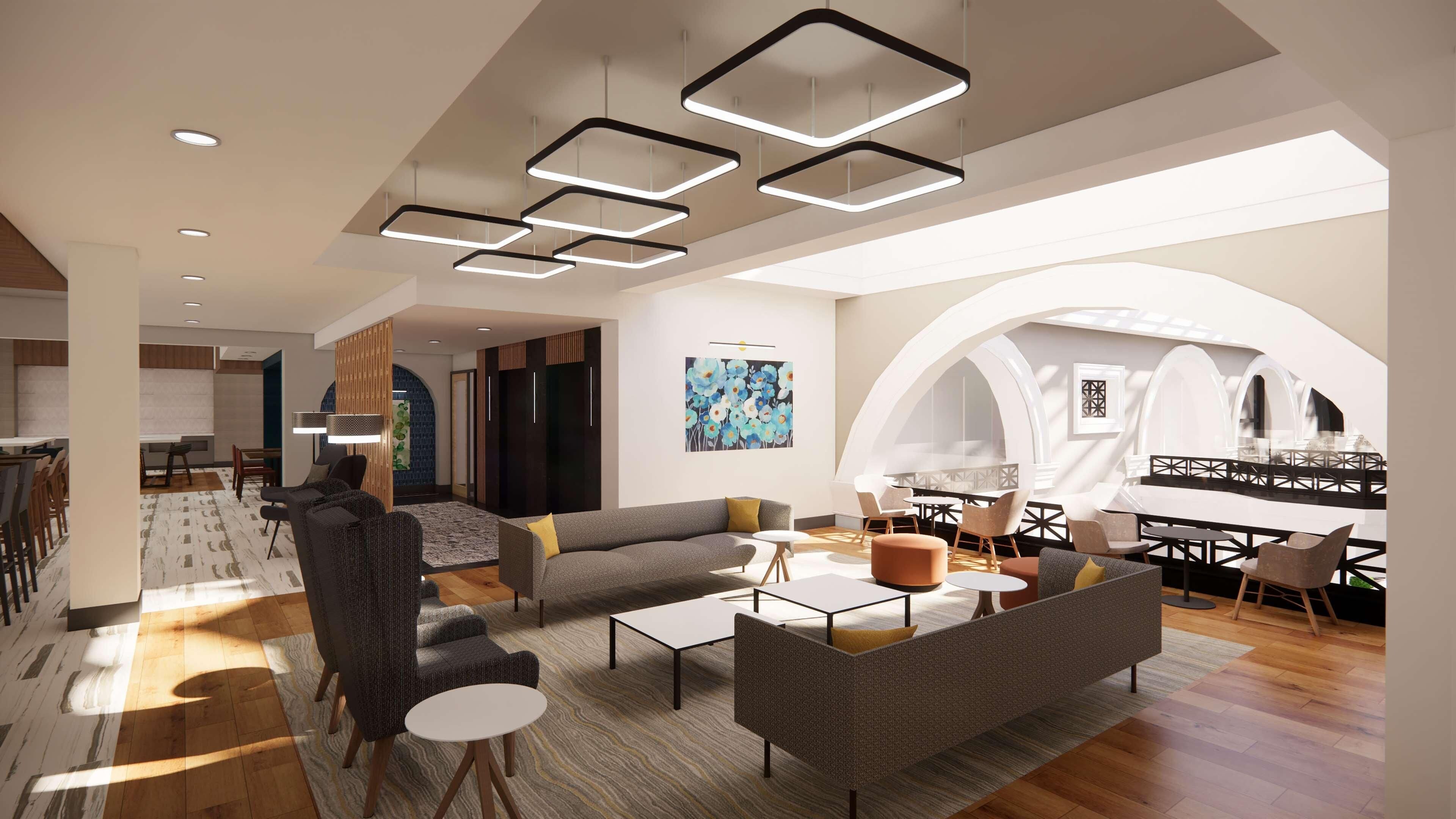 A modern interior with a dining area, a living room with sofas and coffee tables, and a large arched window providing natural light.