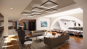 A modern interior with a dining area, a living room with sofas and coffee tables, and a large arched window providing natural light. - Hilton Garden Inn Dayton Downtown (Dayton)