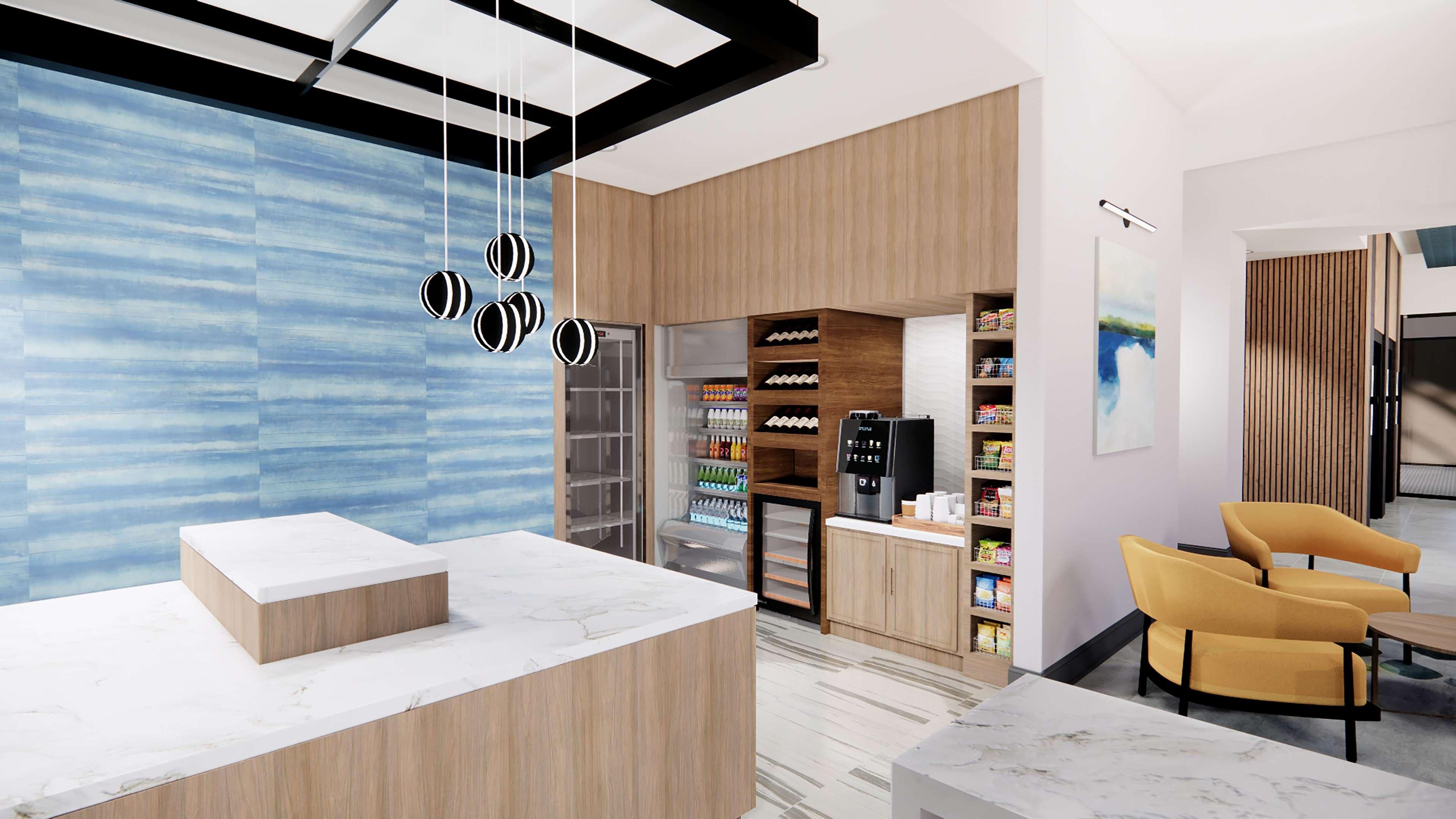 A modern reception area with a marble counter, wooden cabinets, a vending machine, and a yellow armchair.