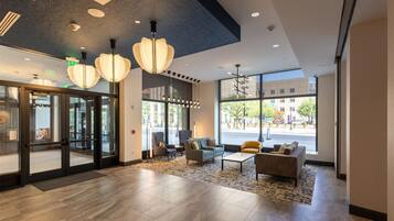 A lobby with modern furnishings, large windows, and a view of the street.