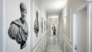 Ein Korridor mit Marmorstatuen an den Wänden und einem polierten Boden.