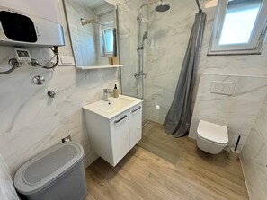 Een douche, handdoeken, toiletpapier