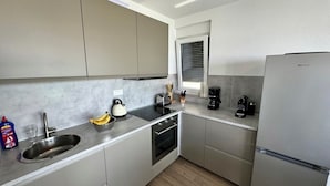 A modern kitchen with grey cabinets, a stainless steel refrigerator, a coffee maker, and a kettle. - Villa Heavenly Beauty (Crikvenica)