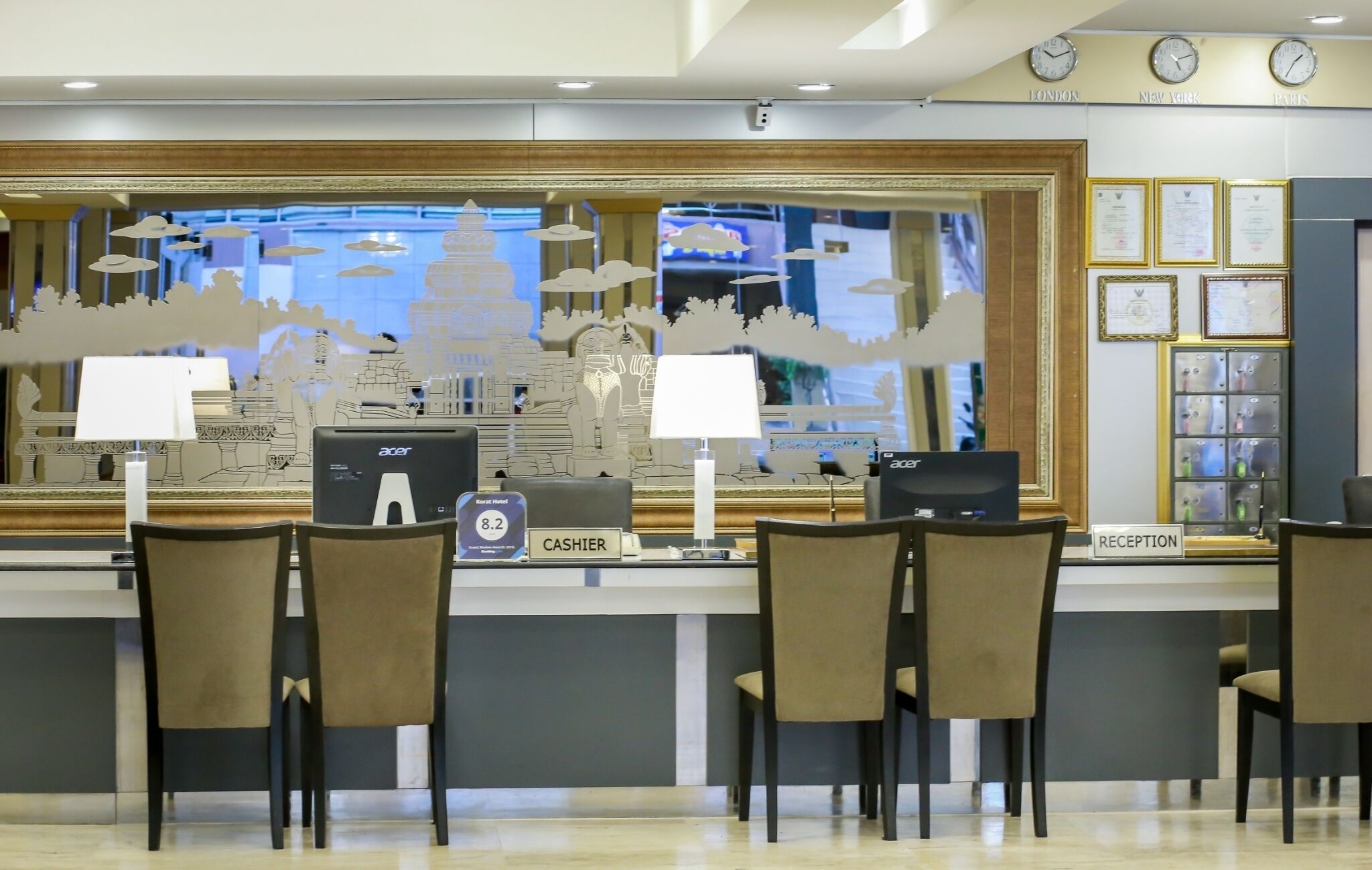 A reception desk with two computers, a cash register, and a sign indicating the Koratt Hotel.