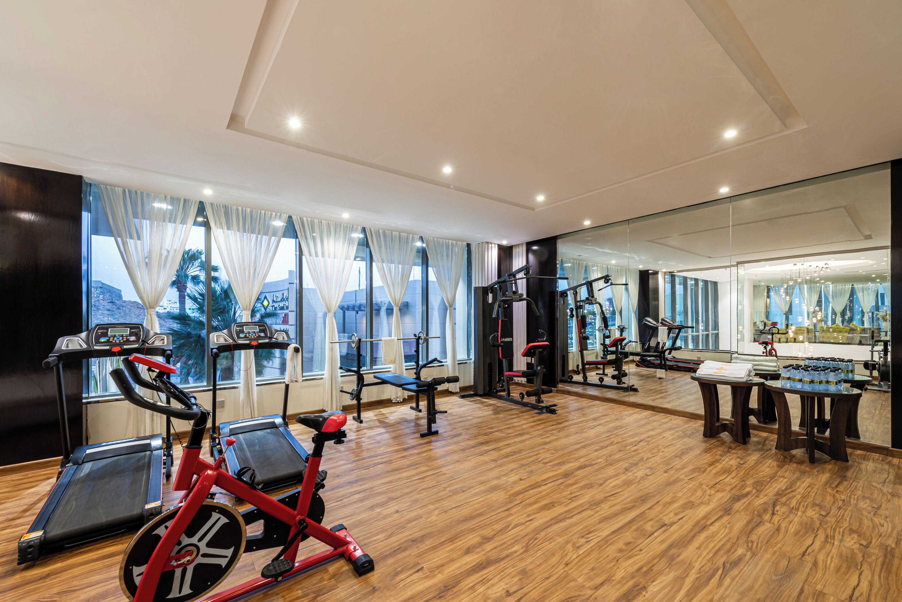 Un gimnasio con cintas de correr, elípticas y máquinas de pesas.