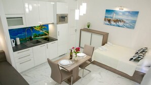 A compact hotel room with a kitchenette, a dining area, and a bed. - Apartments Sun Dance 2 With Heated Pool (Novalja)