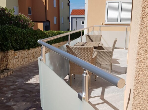 A balcony with wicker furniture and a metal railing. - Apartments Sun Dance 2 With Heated Pool (Novalja)