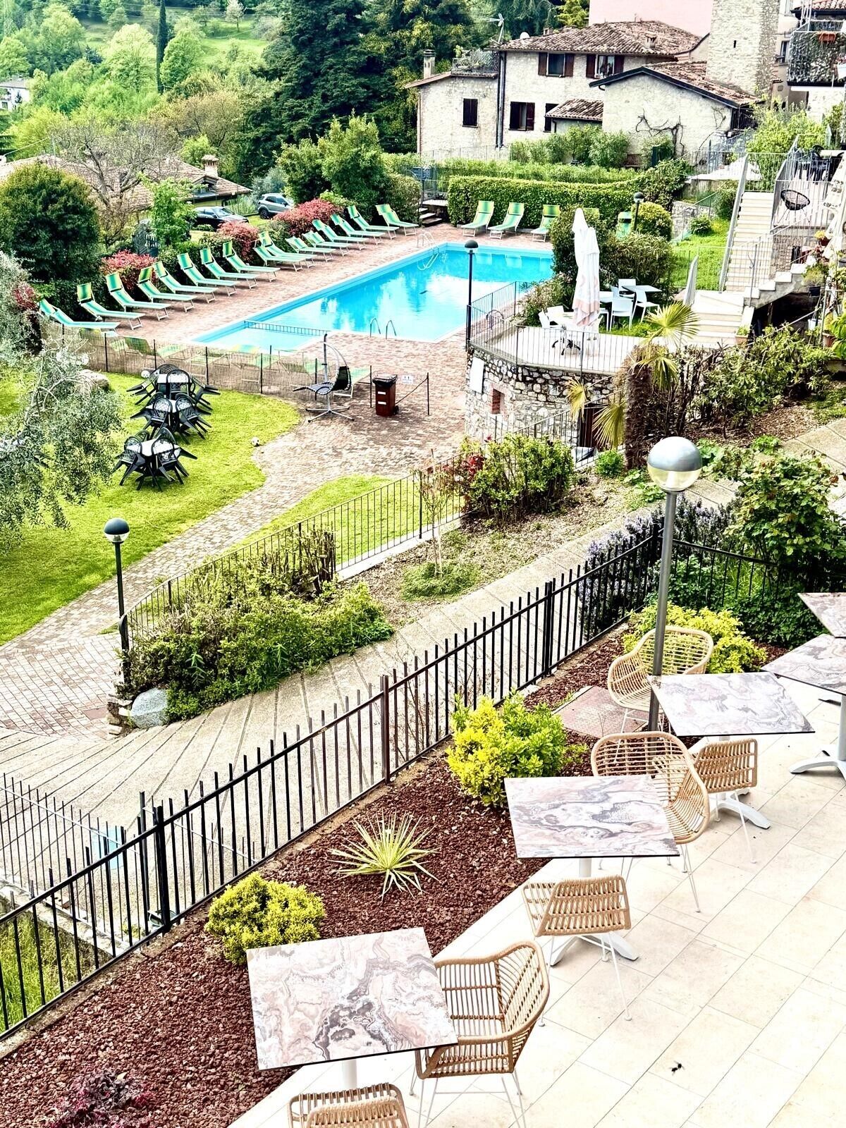 Ein Poolbereich mit Liegestühlen und einem Steinhaus im Hintergrund.