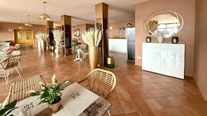 A spacious hotel lobby with high ceilings, modern furniture, and decorative plants. - Hotel MioMio (Tignale)