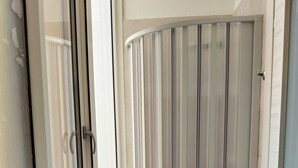A corner room with a sliding glass door, a curved white door, and a white wall.