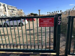Un área de estacionamiento con acceso restringido e indicación de entrada protegida.