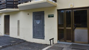 A building with a balcony, a door labeled "LES CARLINES 2", and a large glass entrance.
