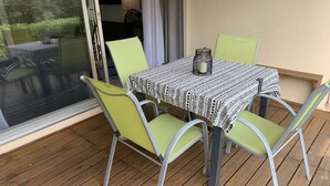 A patio with a table and chairs, a candle holder, and a view through a glass door. - Studio for 4 people in Port Camargue (Port Camargue)