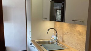 A compact kitchen with a sink, a microwave, and a stove.