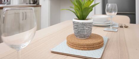 Una mesa con una planta en maceta, un pastel y una copa de vino.